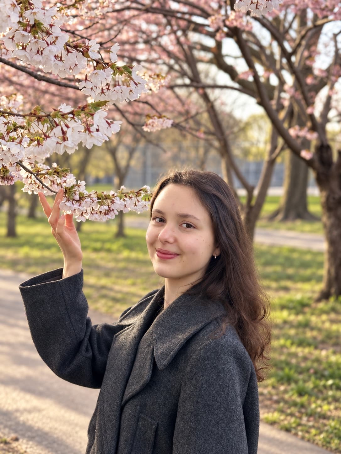 Tanya smiling under spring cherry blossoms